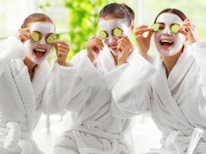 Three friends relaxing in bathrobes with face masks