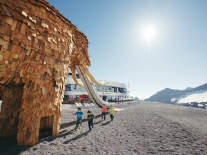 Children playing at the mammoth-themed high-altitude playground at the Stubai Glacier
