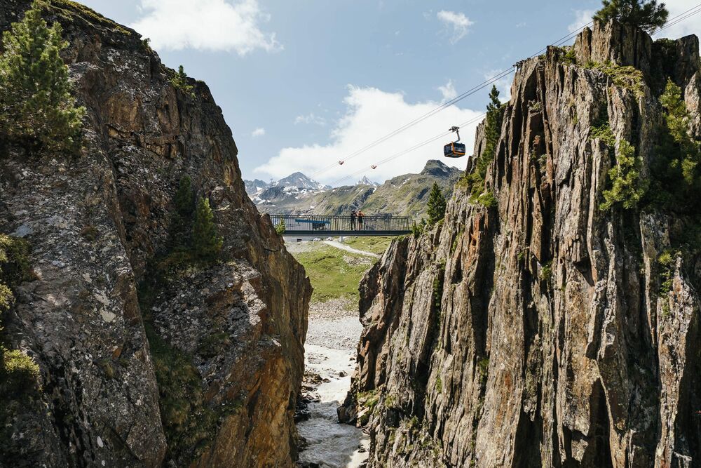 Br&uuml;cke und Gondel der Stubaier Gletscherbahn &uuml;ber einer Felsschlucht
